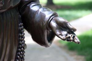 Three rings sit in the palm of the Saint Mary 西奥多。 Guerin's sculpture's hand